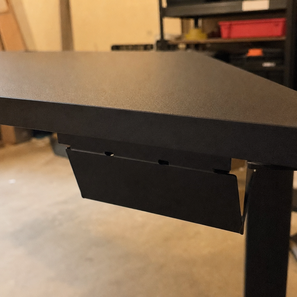 Underside of the Epoch desk showing the steel cable tray mounted flush beneath the surface