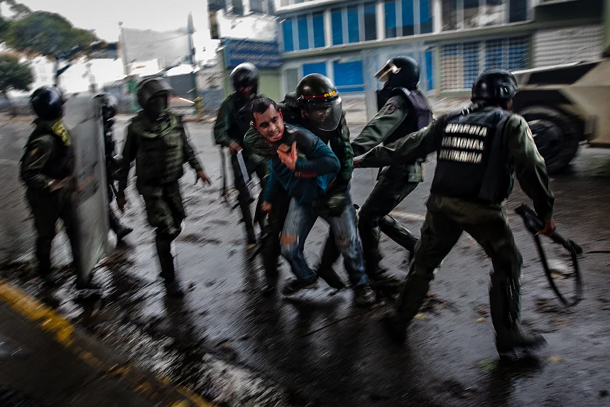 Members of the national guard taking down a man in the protests. Photo by Leo Álvarez (2017).