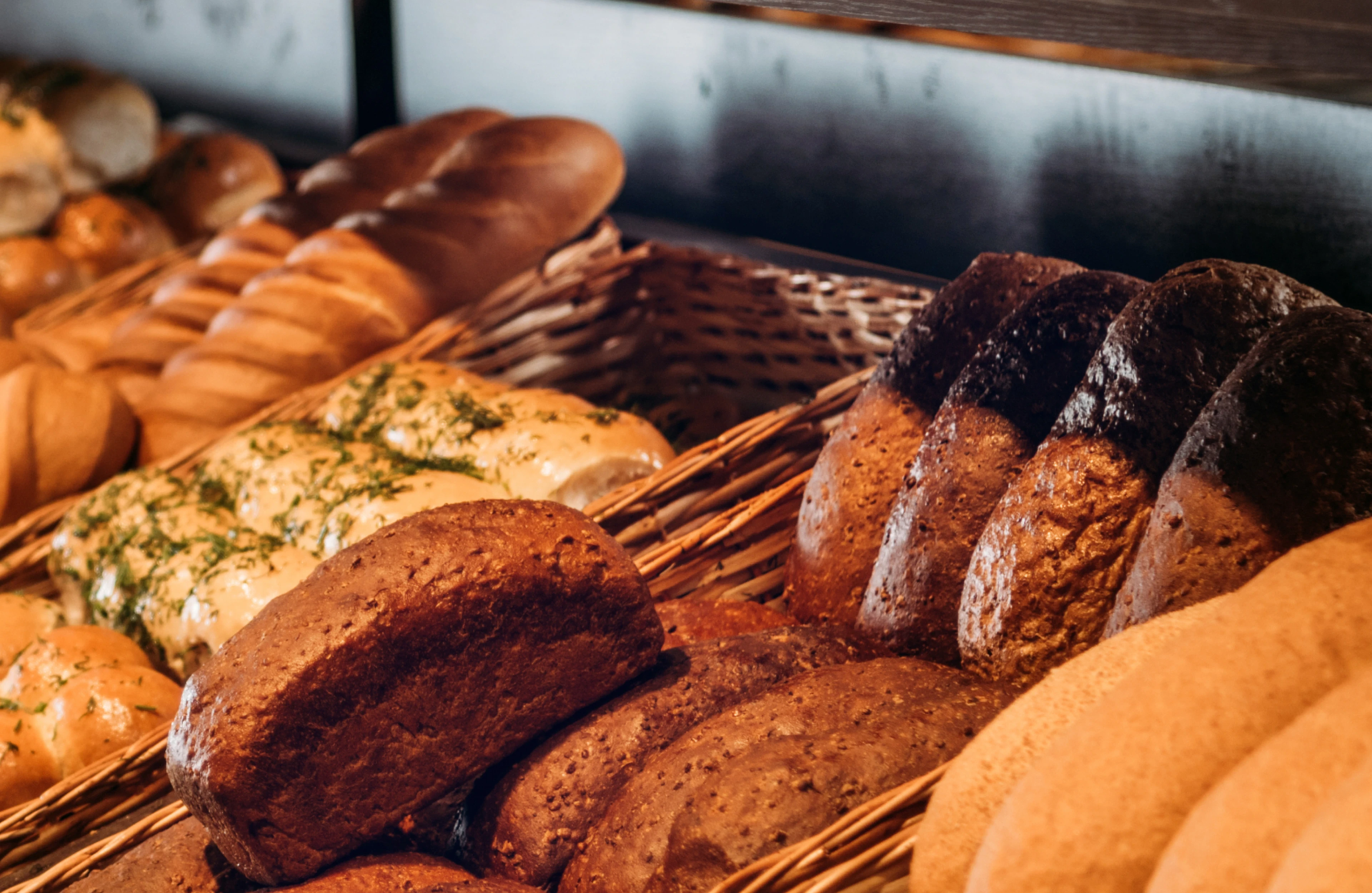 Close-up of assorted breads in warm lighting representing Kitzu’s bakery products.