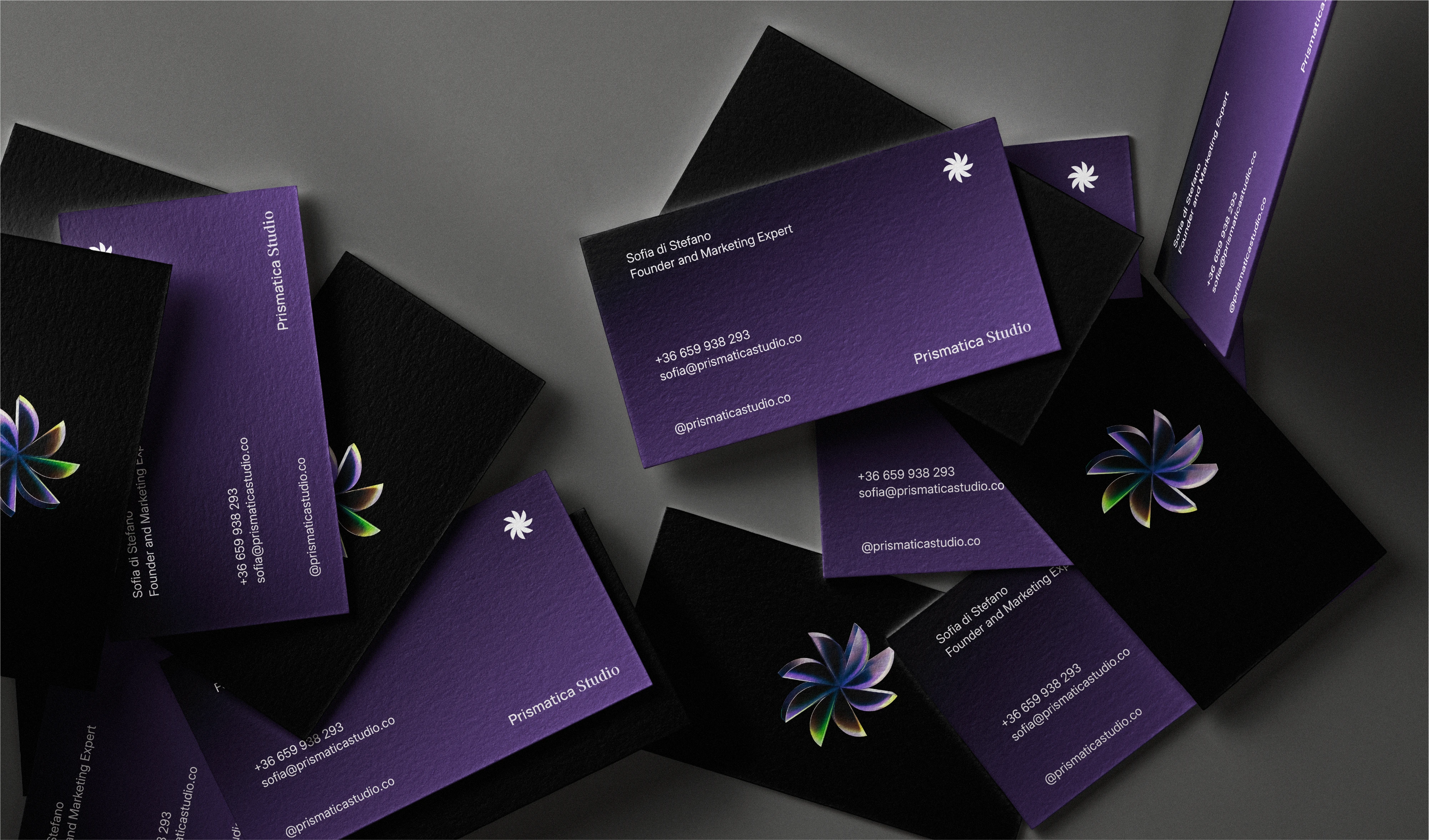 A close-up of Prismatica Studio business cards, highlighting the texture and vibrant purple alongside the black, showcasing the elegant and tangible brand experience.