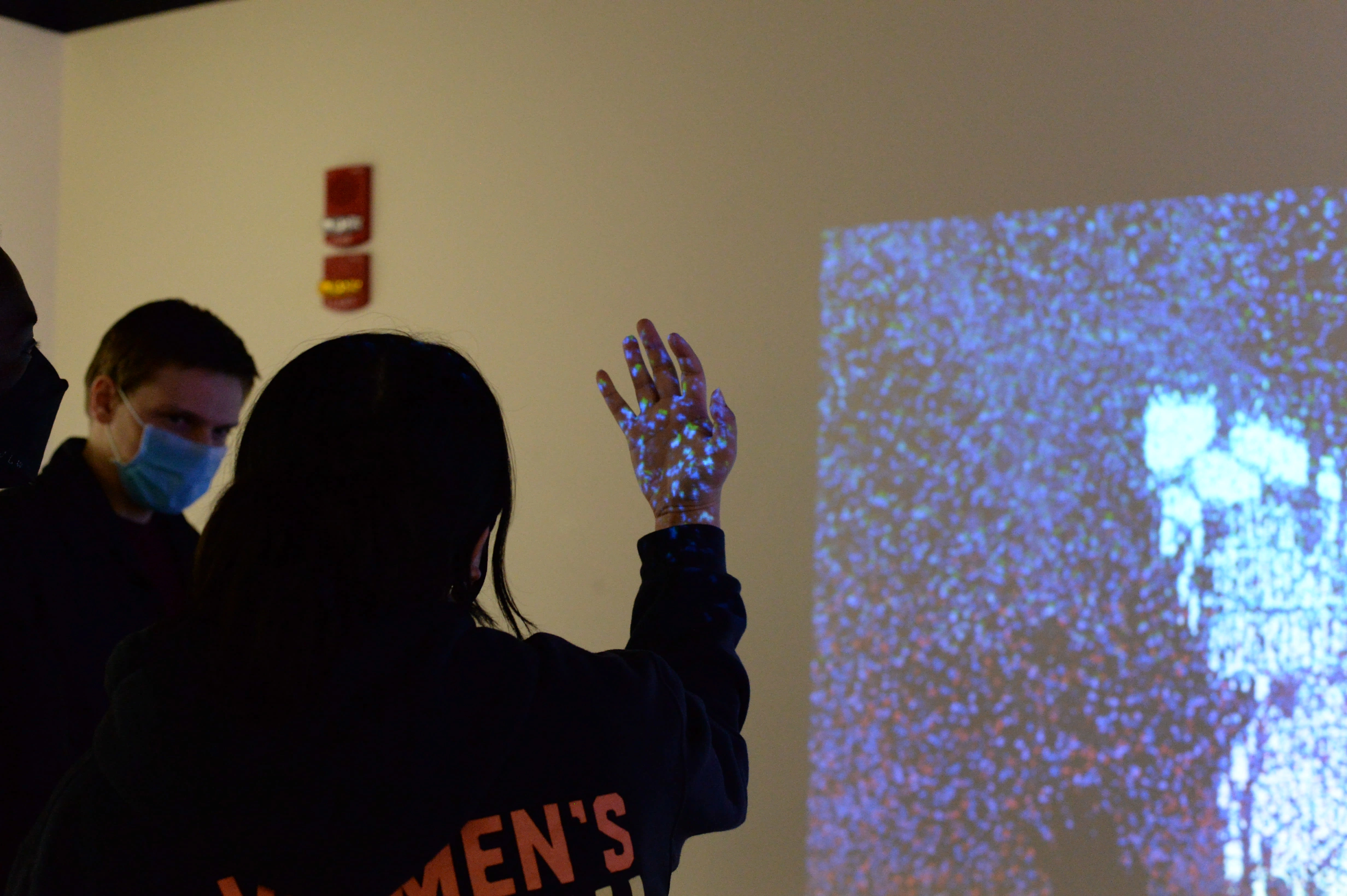 Visitor engaging with interactive particle projection.