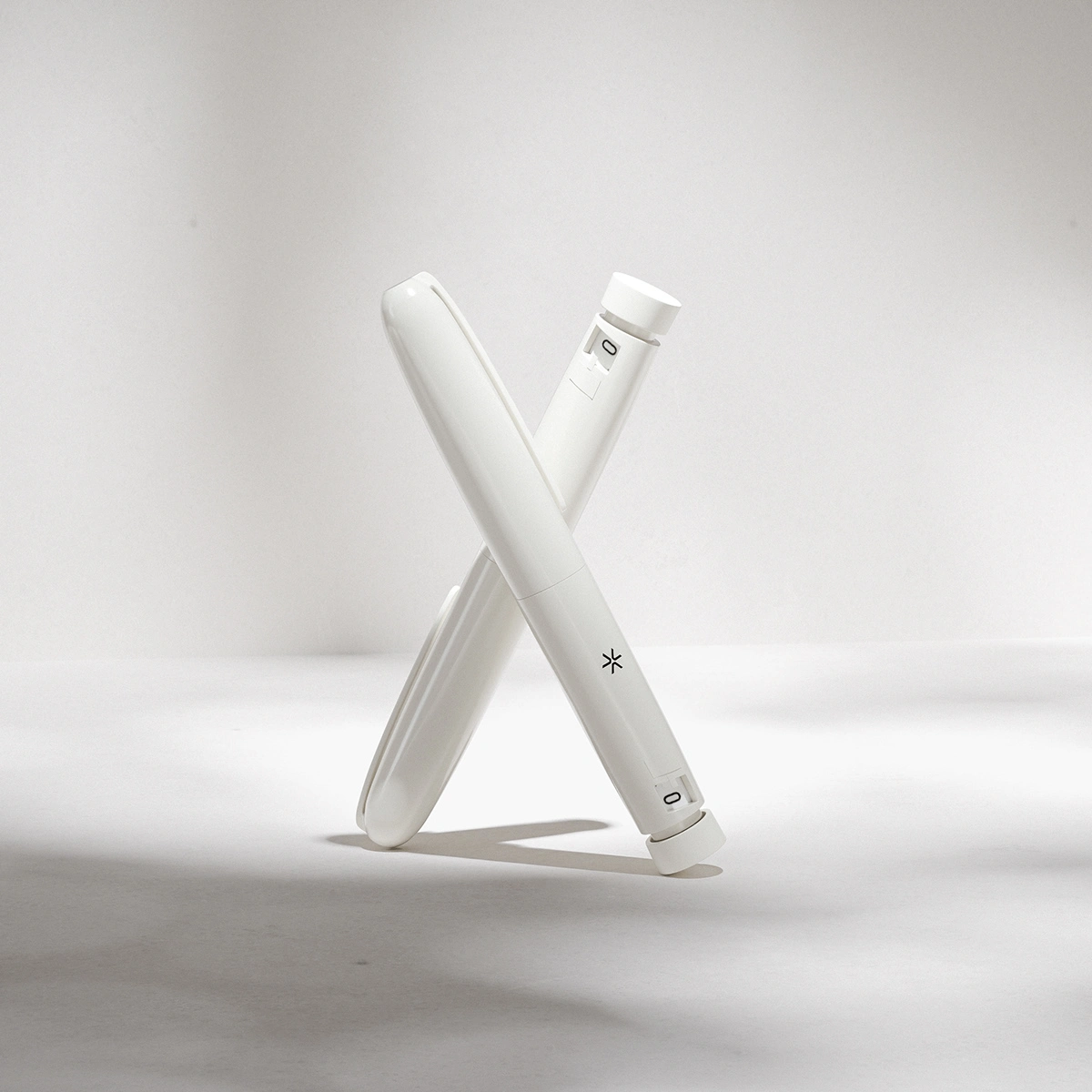 The white pens crossed on a clean backdrop bring focus to sleek, functional design.