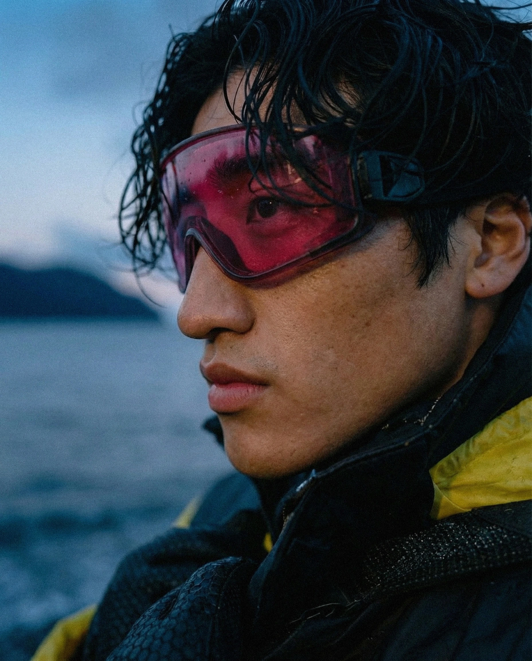 Campaign visual showcasing functional outerwear in real-world, cold coastal conditions