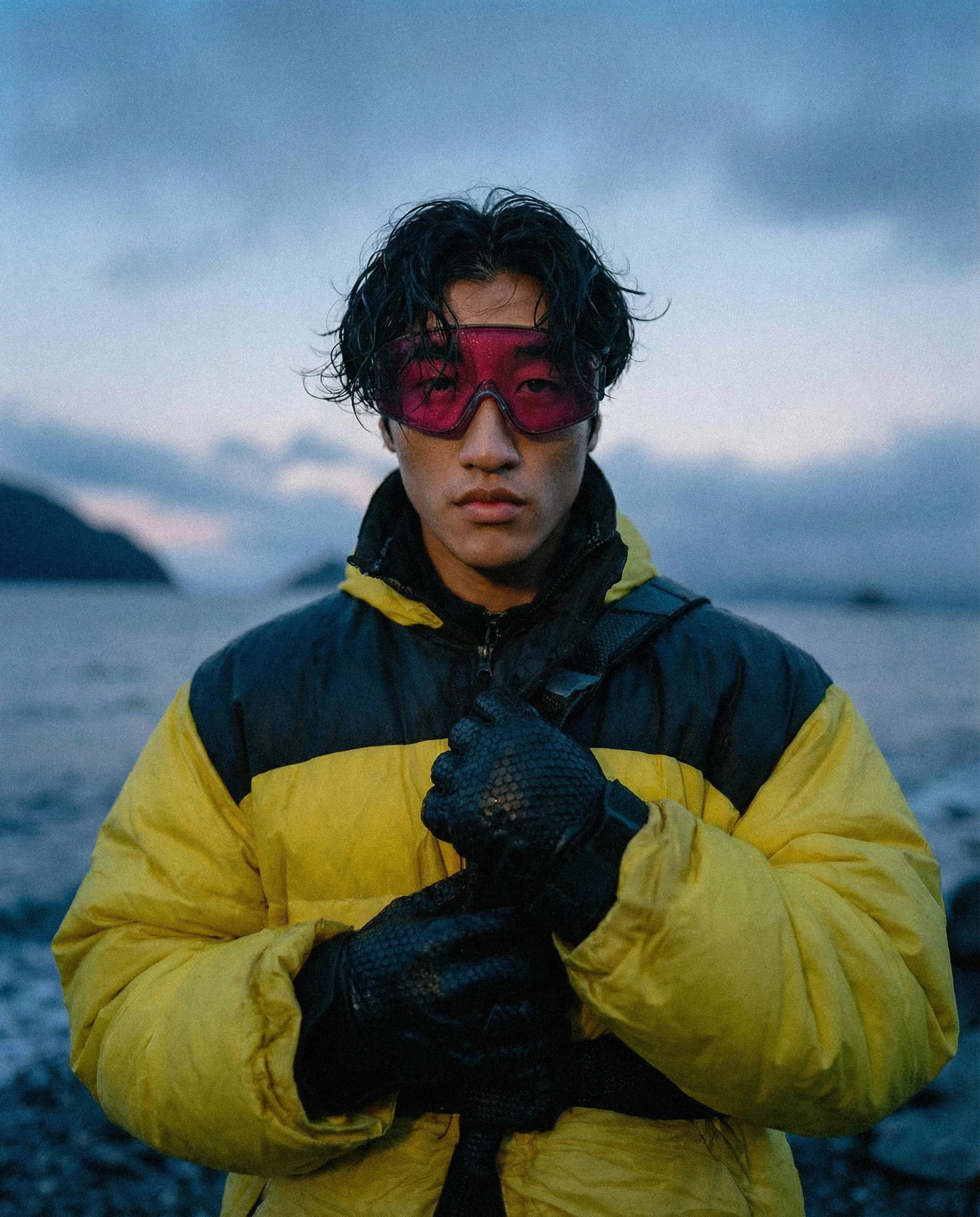 Campaign visual showcasing functional outerwear in real-world, cold coastal conditions