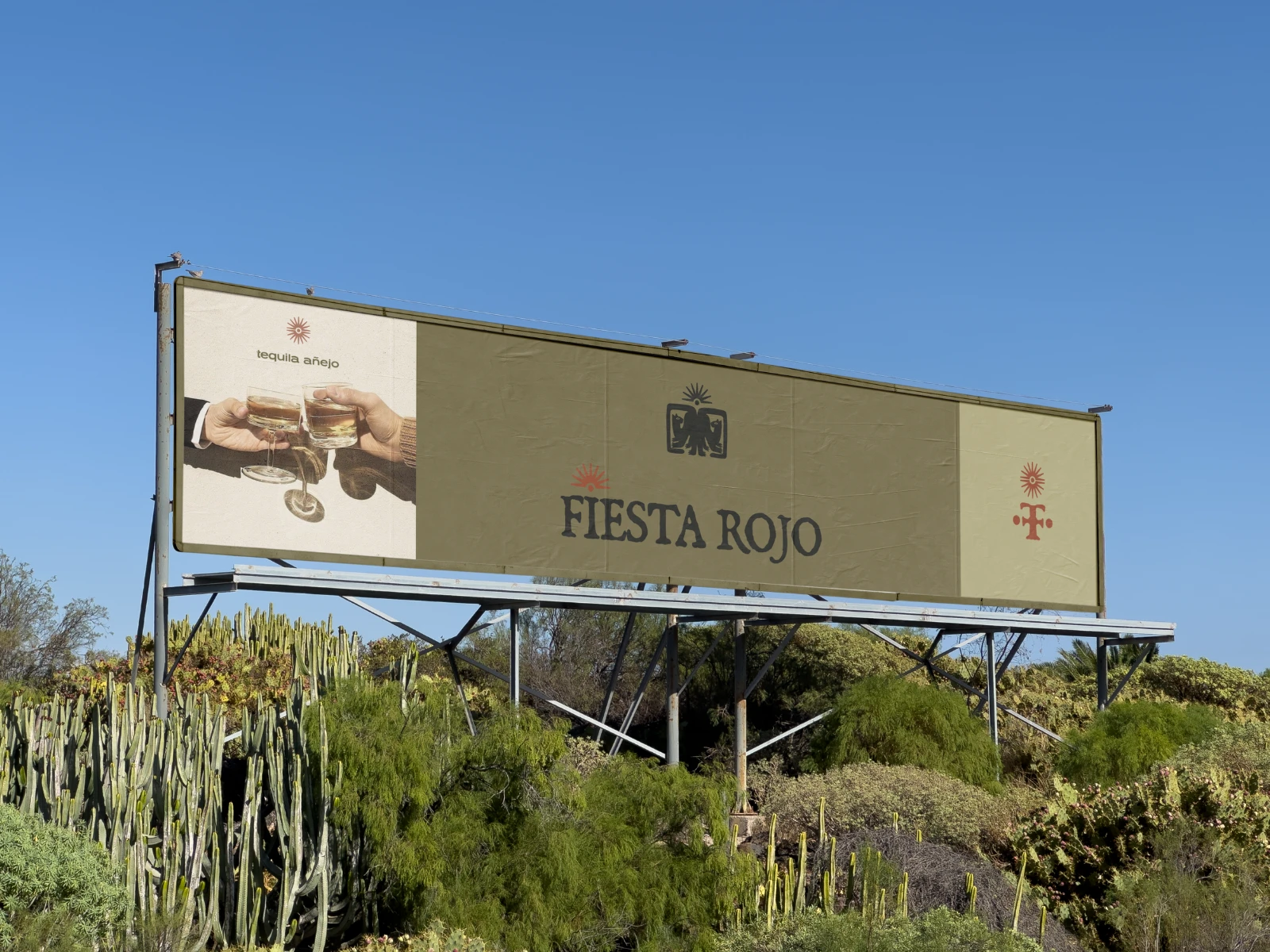 A billboard surrounded by cacti, showcasing the brand’s main logo, submark and an image associated with the brand. Every choice is intentional — from the color palette that blends seamlessly into the surroundings to the visual storytelling that reflects the essence of this aged tequila made with local, natural ingredients.
The deep red accent, inspired by the color of a sunset on a scorching day, adds warmth and depth. A stylized custom illustration — placed above the “i” in the main logo and above the submark on the far right — combines sun, sunrays + the agave plant, the heart of tequila itself.