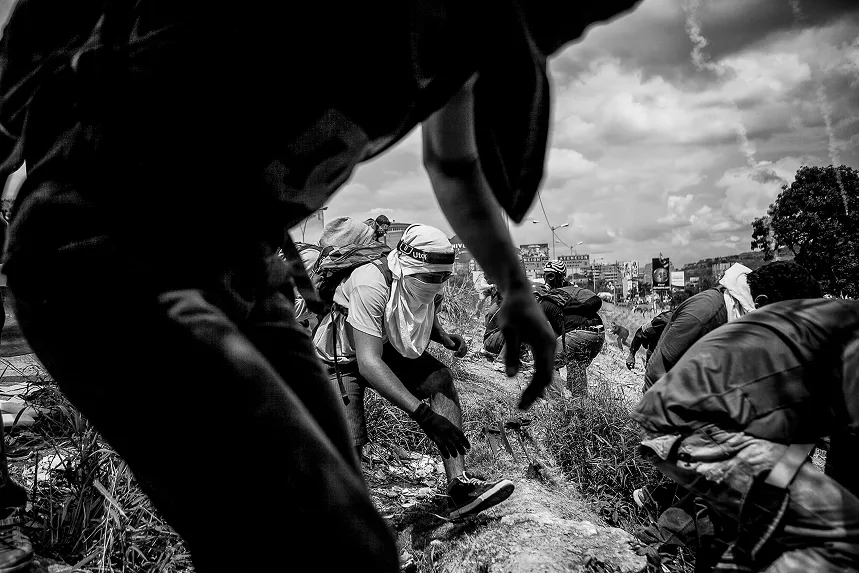 Young guys hiding and running from the tear gas and the national guard.Photo by Alejandro Cegarra (2017).