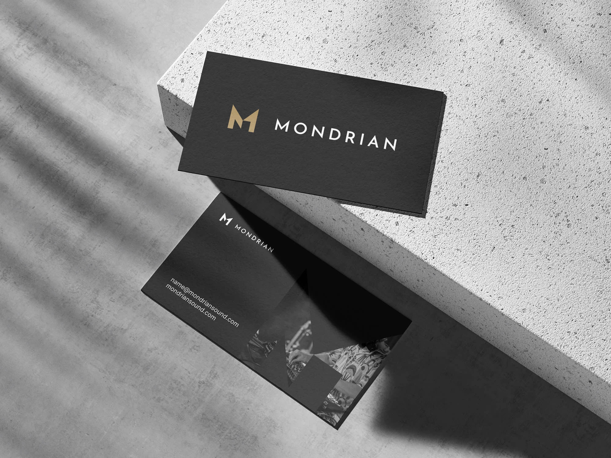 Application of the Mondrian identity on business cards, highlighting typography, symbol usage, and material texture.