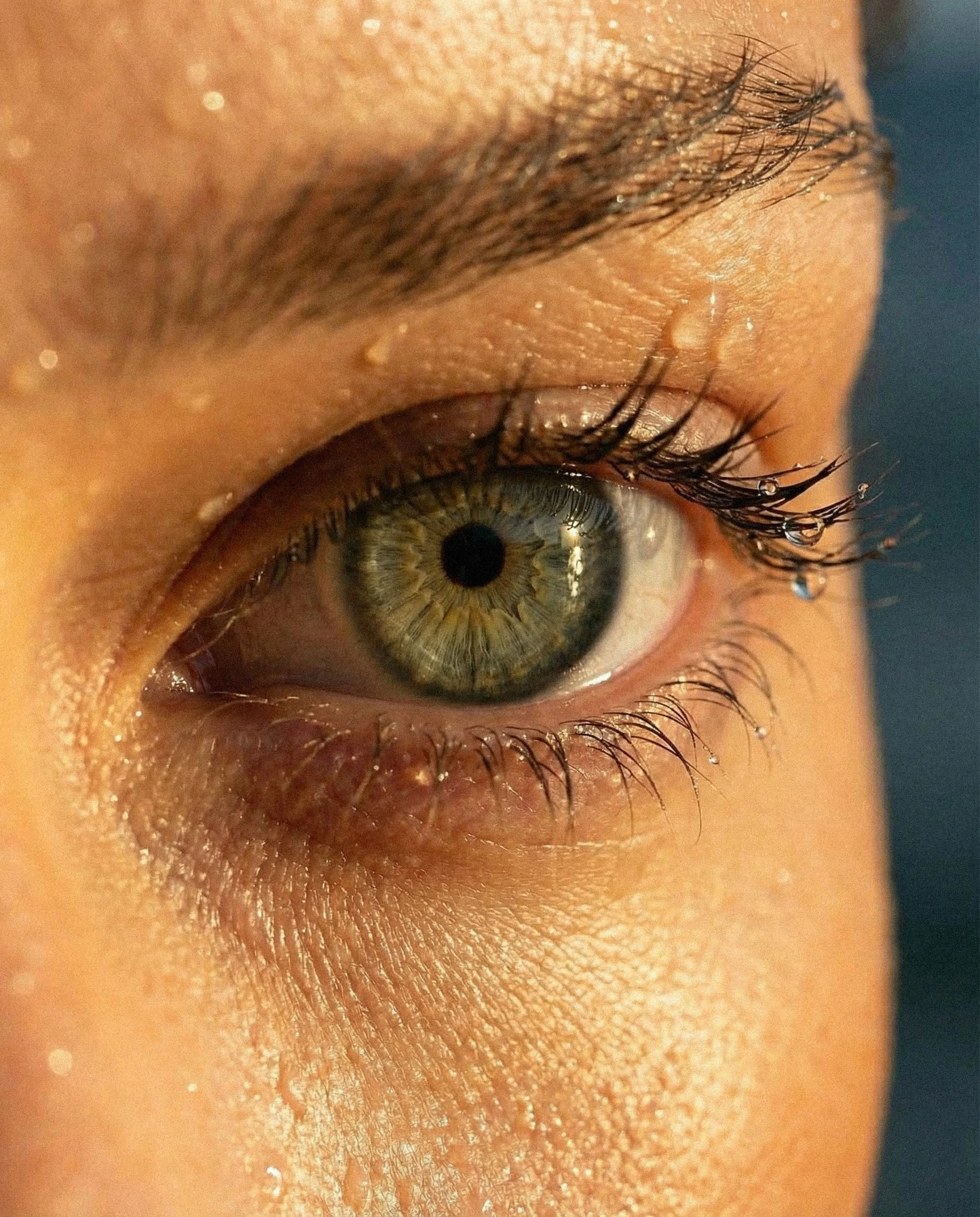 Extreme close-up capturing skin, water, and natural light in raw detail.