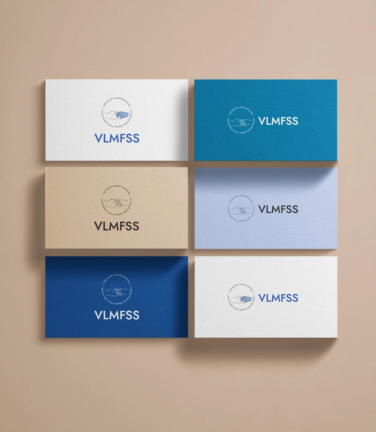 Mockup of the VLMFSS logo on business cards of different colours.