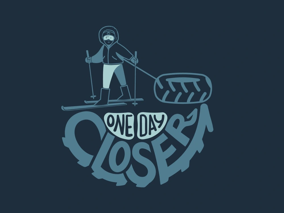 "One Day Closer" skier design, on the back of the navy shirt