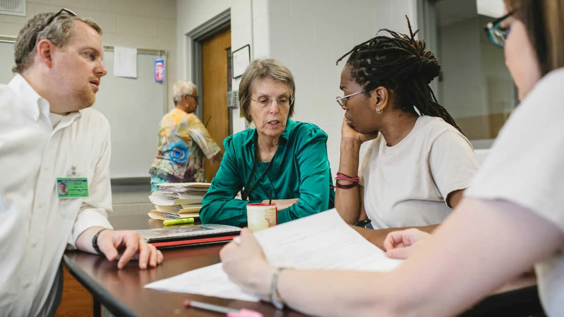 Andrew Falk (from left) works with former volunteer Kelsey Kauffman, Michelle Jones and Natalie Medley in the housing policy class at Indiana Women's Prison in Indianapolis on May 17. (Andrew Spear for The Marshall Project)