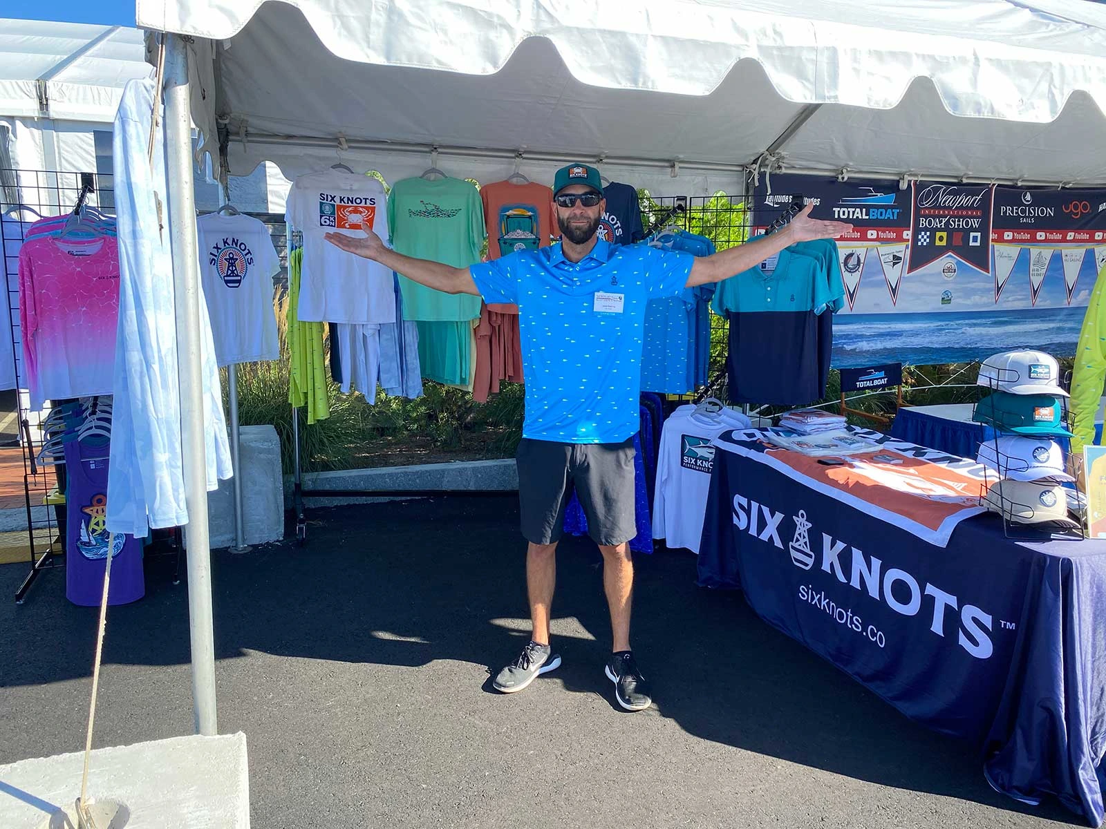 John, a Six Knots co-owner, shows off the booth at the Newport International Boat Show