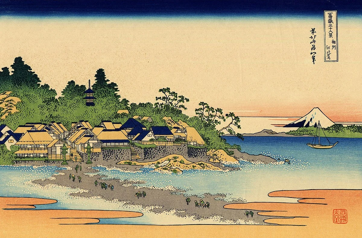 Wikipedia - This is an illustration of the Japanese island of Honshu’s Pacific Coast, Enoshima Island. Traditional Japanese homes with yellow roofs are depicted in the illustration beside the seashore and beach, while a mountain can be seen in the background.