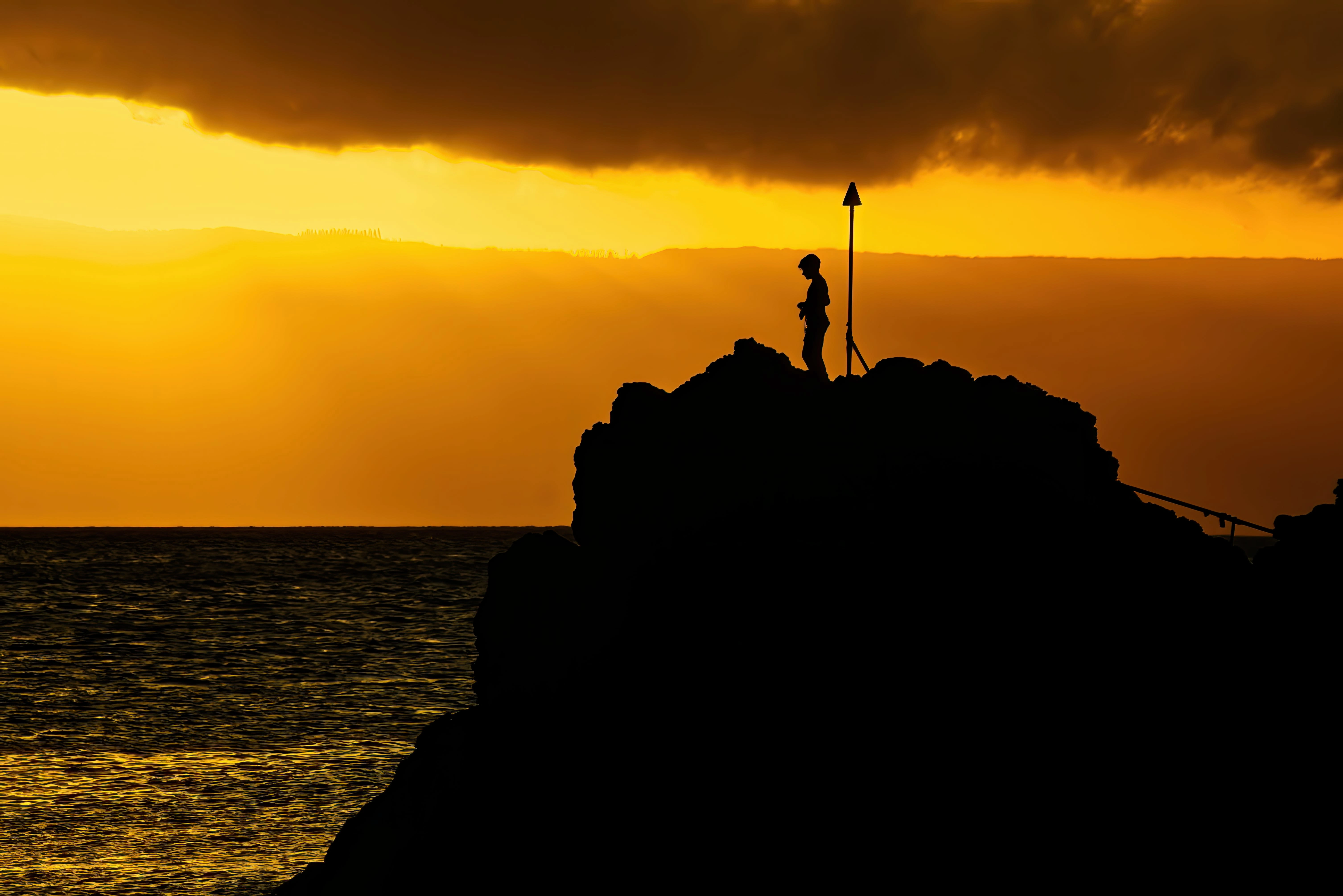 A hiker stands atop a powerful cliff. (Unsplash)