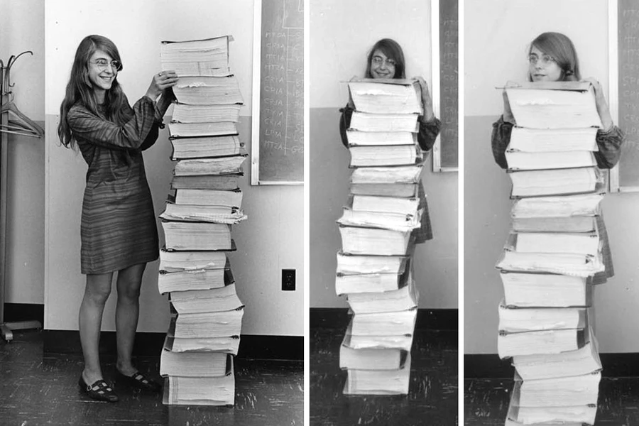 Margaret Hamilton stands next to a stack of Apollo Guidance Computer source code
Image credit: MIT Museum