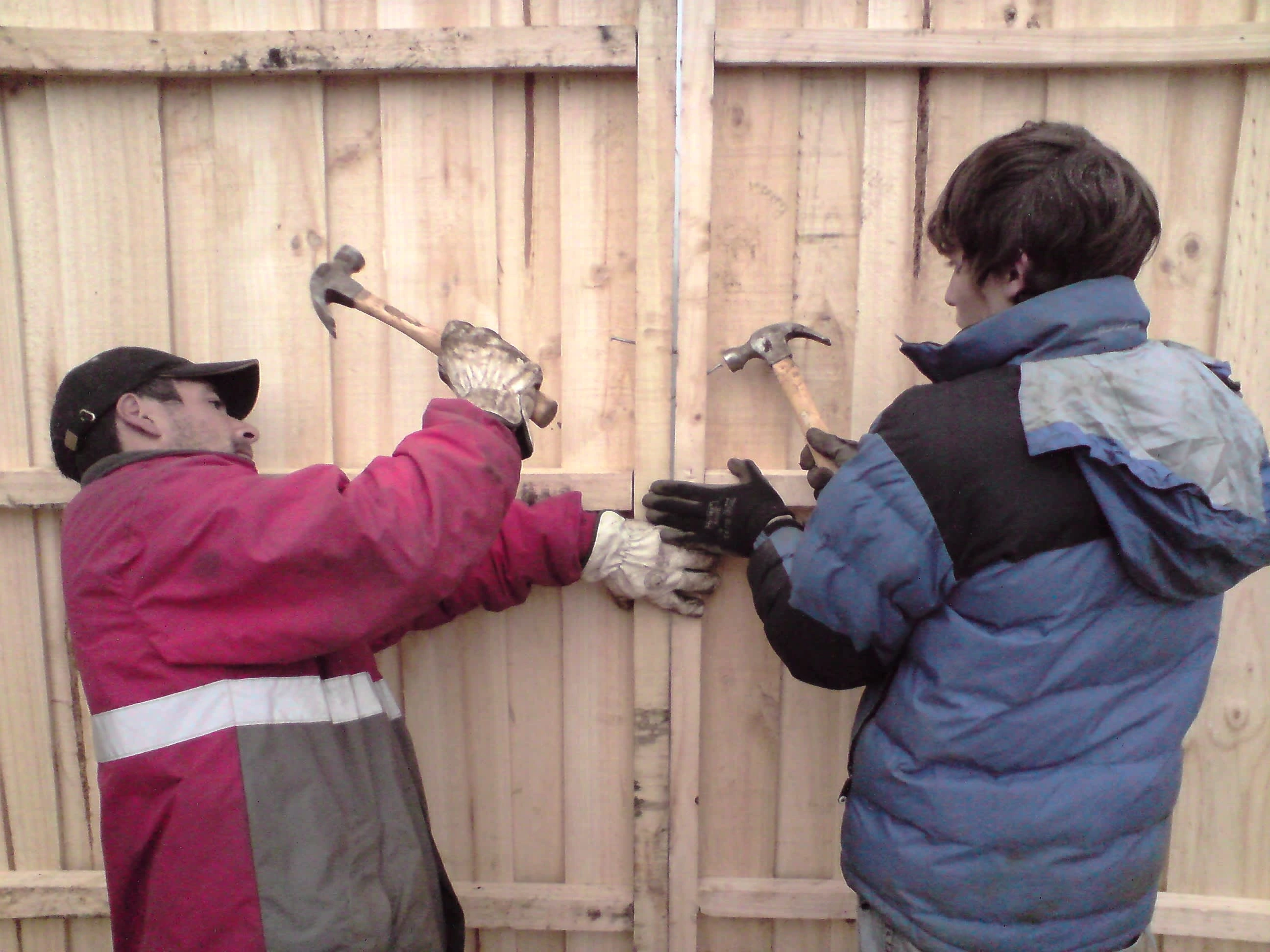 Alejandro and Ubaldo fixing a gap in the wall between two sides of a mediagua using a diagonal nailing technique. Los Lomas in May 2010. Photo by Ben Angel