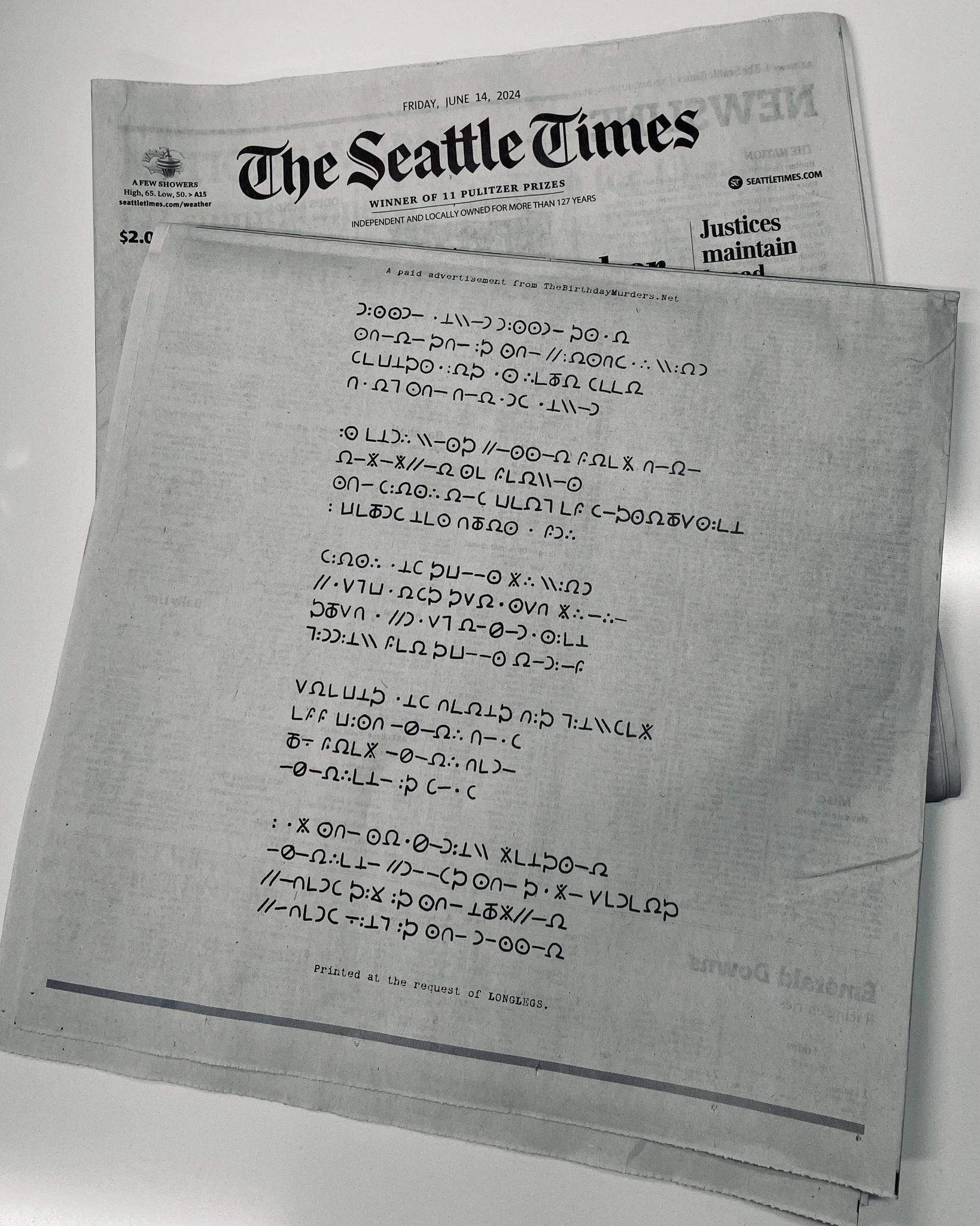 A copy of the Seattle Times with the secret cypher code and a link to thebirthdaymurders.net