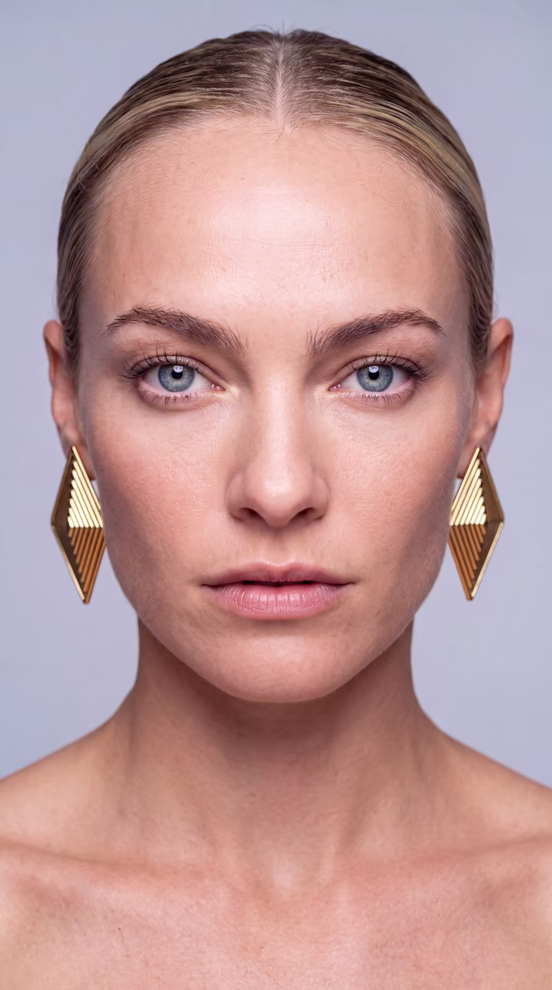 Cover image for Gold geometric earrings under warm